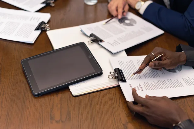 A business meeting with tablets and documents, showcasing digital integration in a professional setting. Spreadsheet or agency software? Start with the client brief